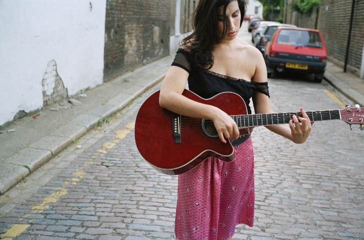 Amy with an acoustic guitar on the streets of Camden, 2003.
