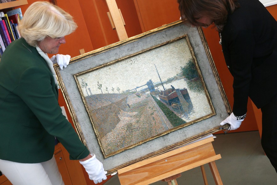 Monika Gruetters (left) hands over the painting ‘Quai de Clichy’ by Paul Signac to Agnes Sevestre-Barbe, representative of the heiress, as part of the return of art stolen under the Nazis and hoarded by Cornelius Gurlitt, the son of Nazi-era dealer Hildebrand Gurlitt in Berlin on July 3, 2019.